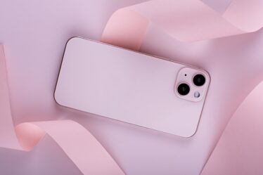Rosa mobiltelefon mot rosa bakgrung