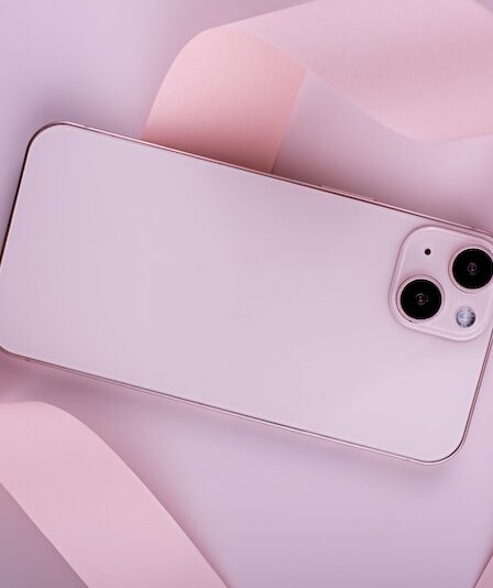 Rosa mobiltelefon mot rosa bakgrung